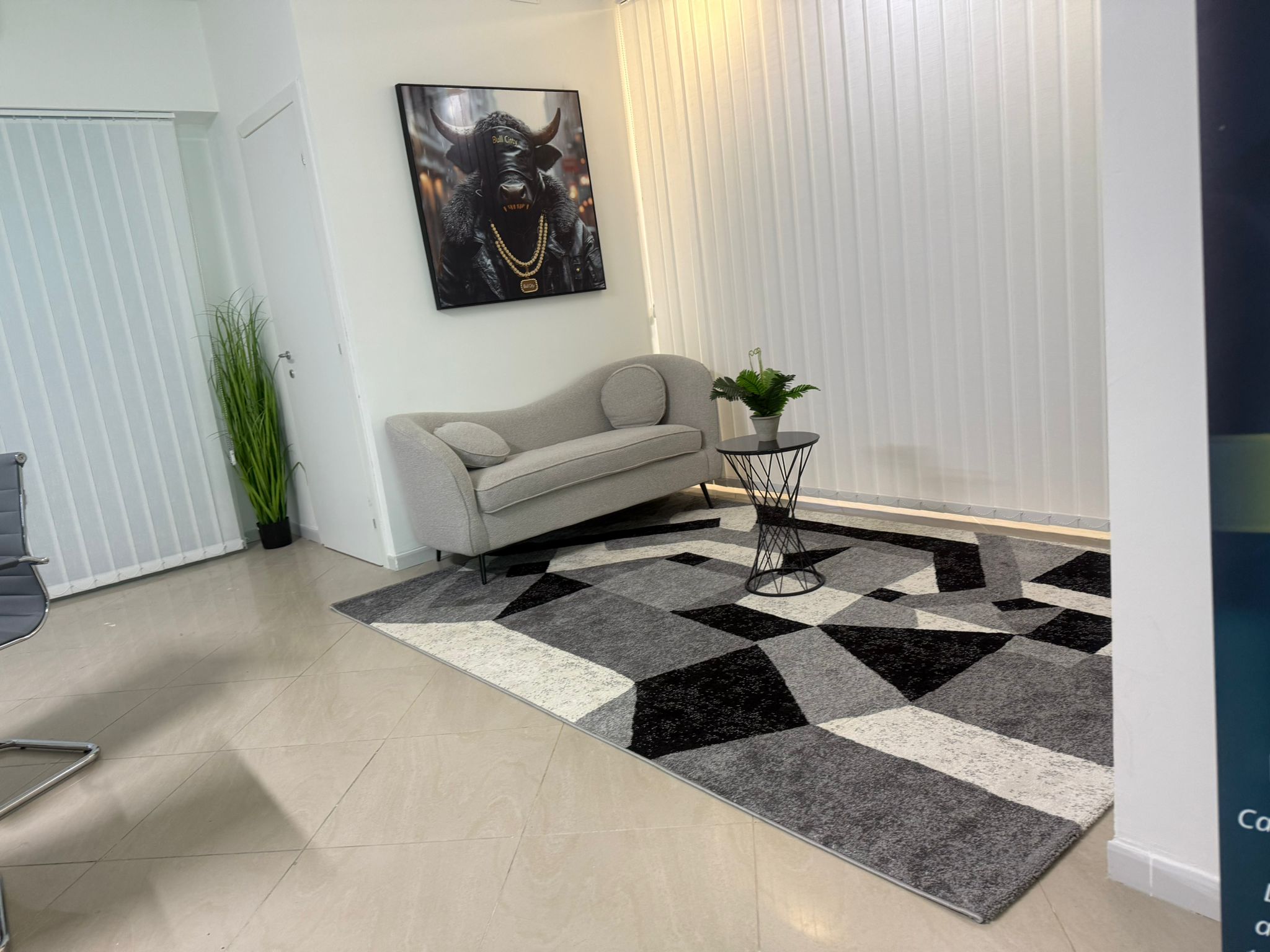 Area lounge con divano, opera toro e tappeto geometrico